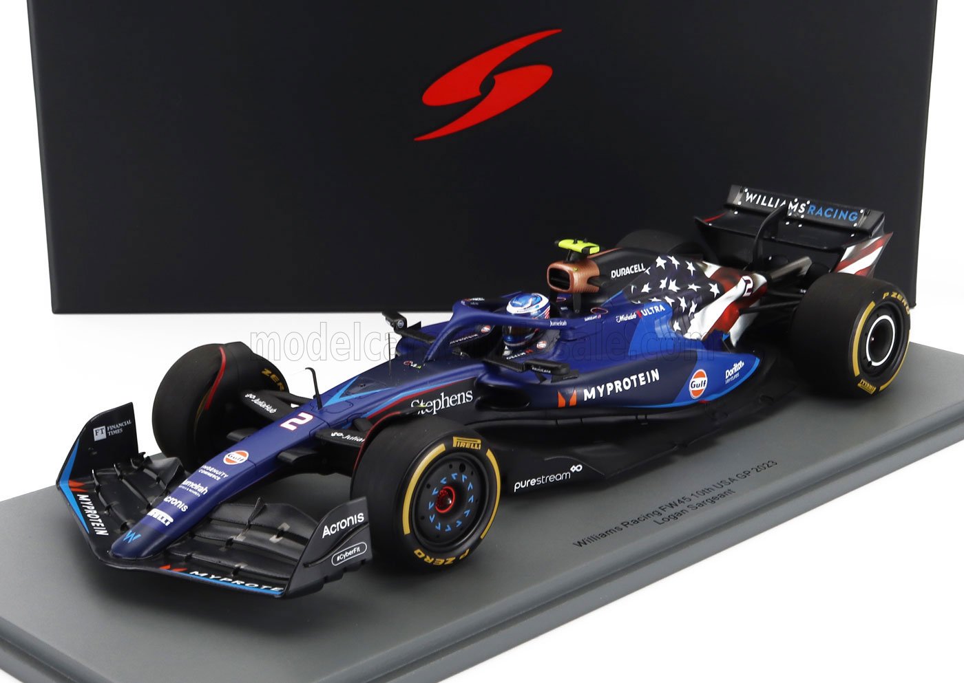 Modelo de coche de Fórmula 1 Williams Racing FW45 2023 con decoración de bandera estadounidense, expuesto en un soporte de exhibición, disponible en Vroomi.