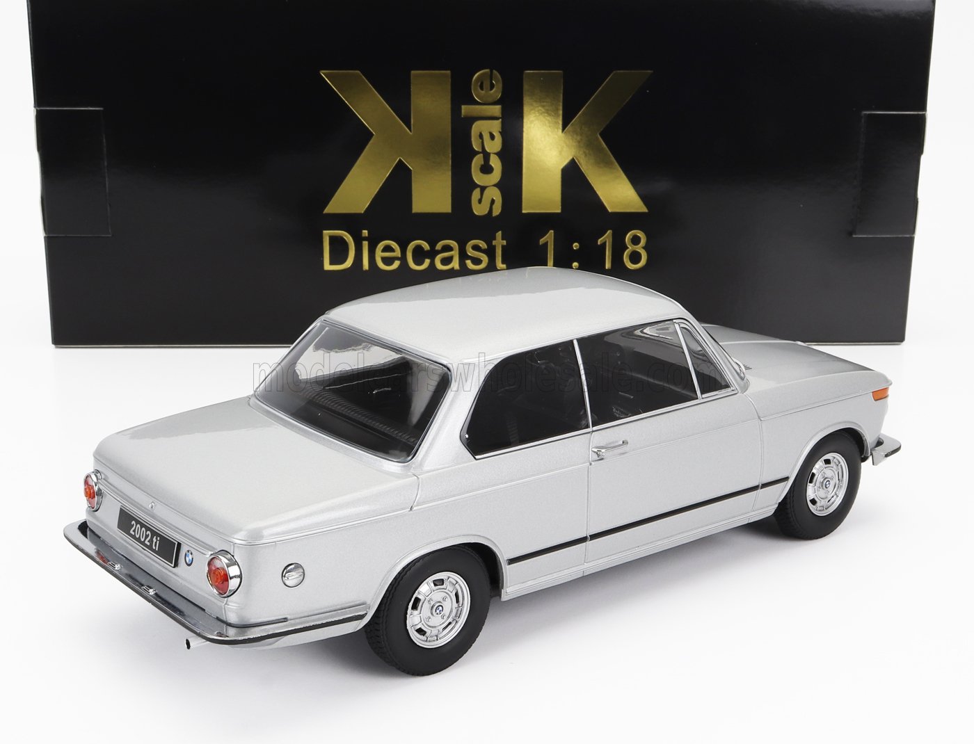 Coche en miniatura BMW 2002 ti a escala 1:18 fabricado en metal fundido a presión, con caja KK Scale negra y dorada, disponible en Vroomi.