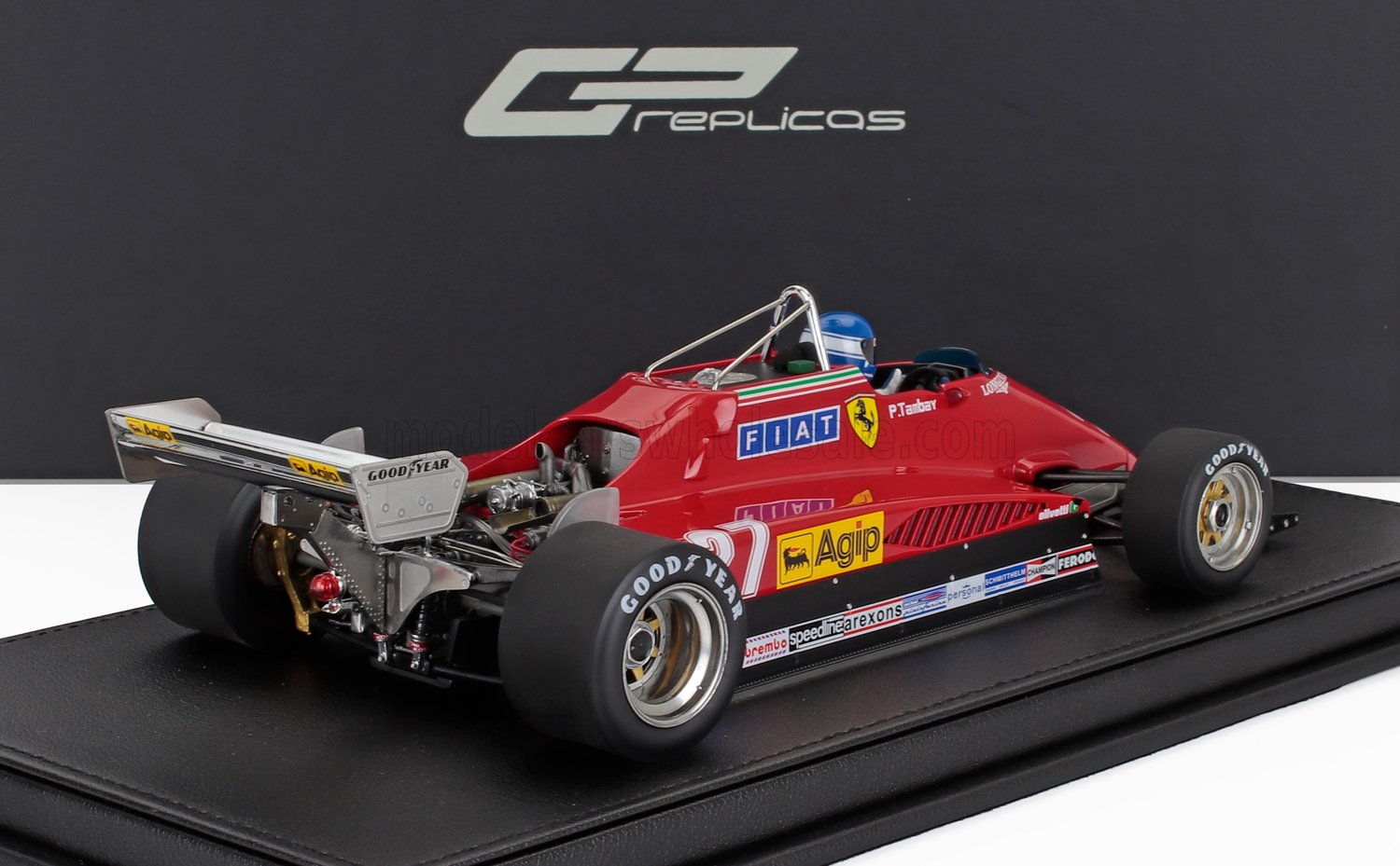 Maqueta de coche Ferrari F1 vintage rojo con neumáticos Goodyear en exposición, disponible a través de Vroomi.