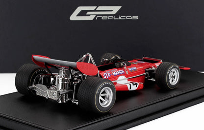 Coche March rojo March 1 con neumáticos Firestone, alerón trasero detallado, expuesto sobre una base negra, a la venta en Vroomi.