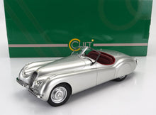 Maqueta de coche clásico roadster plateado con interior rojo, coleccionable y disponible para su pedido en Vroomi.