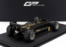 Modelo a escala 1/18 del coche de carreras Lotus F1, negro con detalles dorados, disponible para coleccionistas en línea.