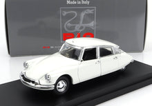 Coche clásico Citroën DS blanco sobre un expositor negro con una caja de la marca Rio detrás, disponible en Vroomi.