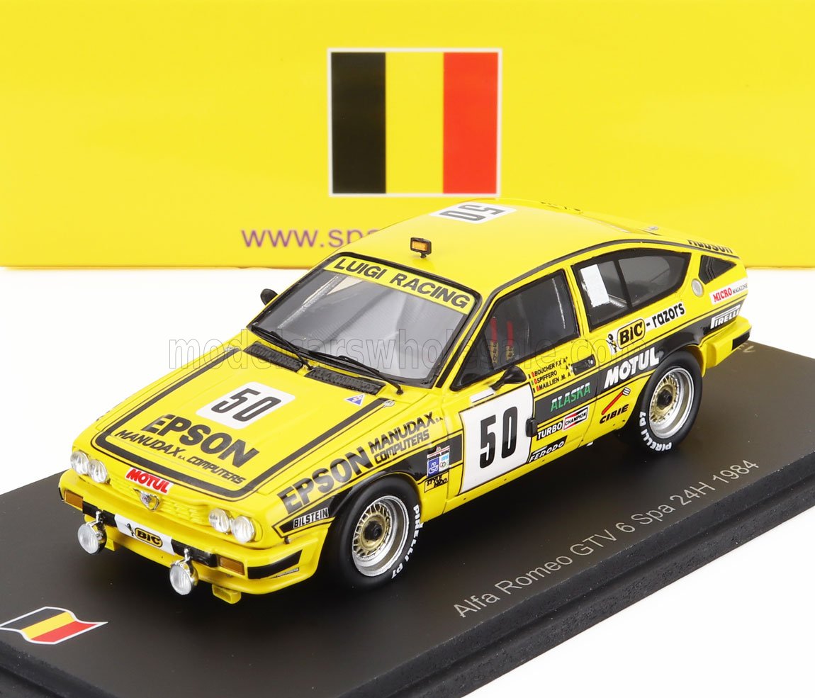 Modelo de coche de carreras Alfa Romeo GTV 6 amarillo con adhesivos de carreras sobre base negra, disponible en Vroomi.
