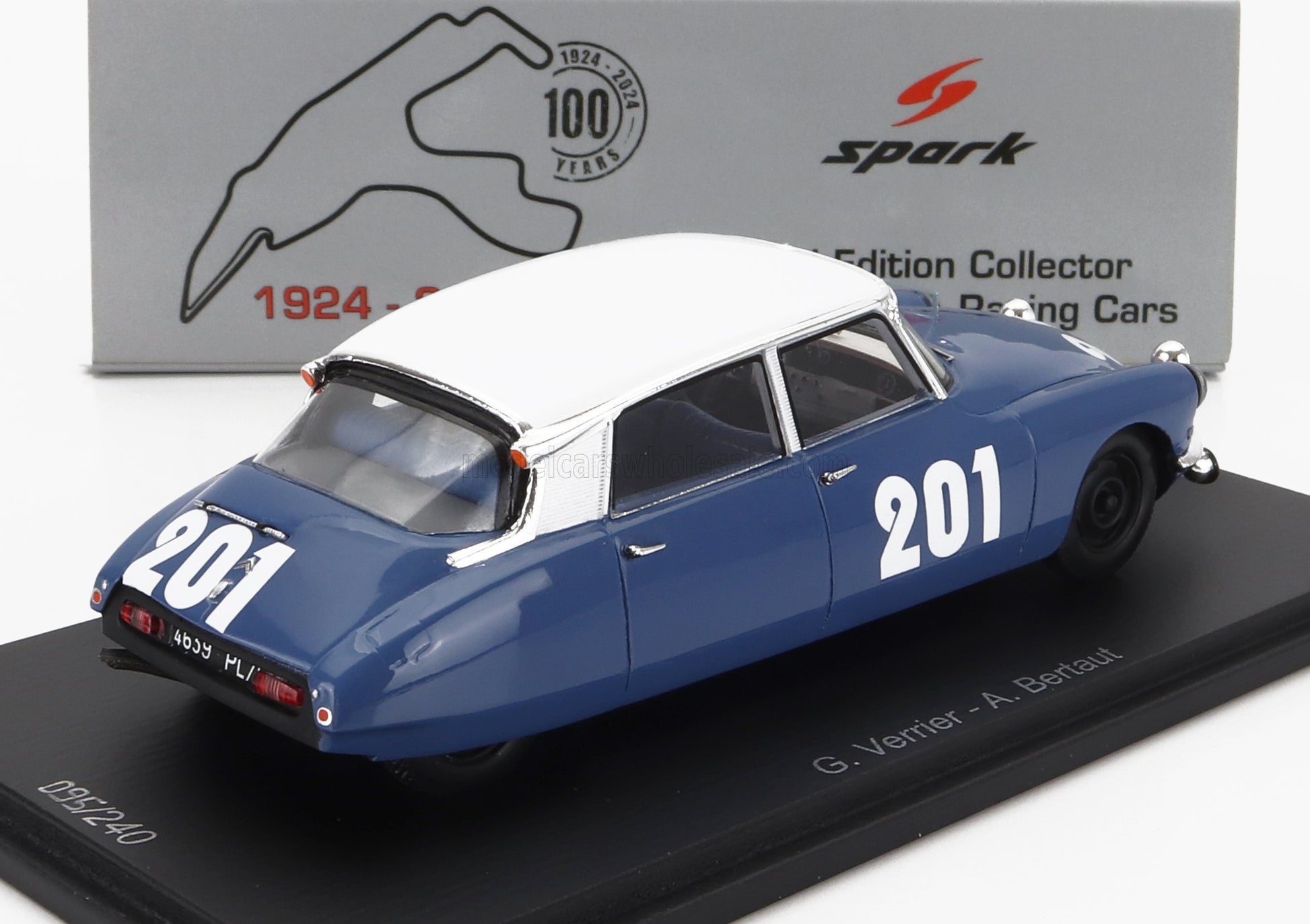 Modelo de coche de carreras vintage azul y blanco n.º 201 sobre base expositora con el logotipo de Spark 100 Years, disponible en Vroomi.