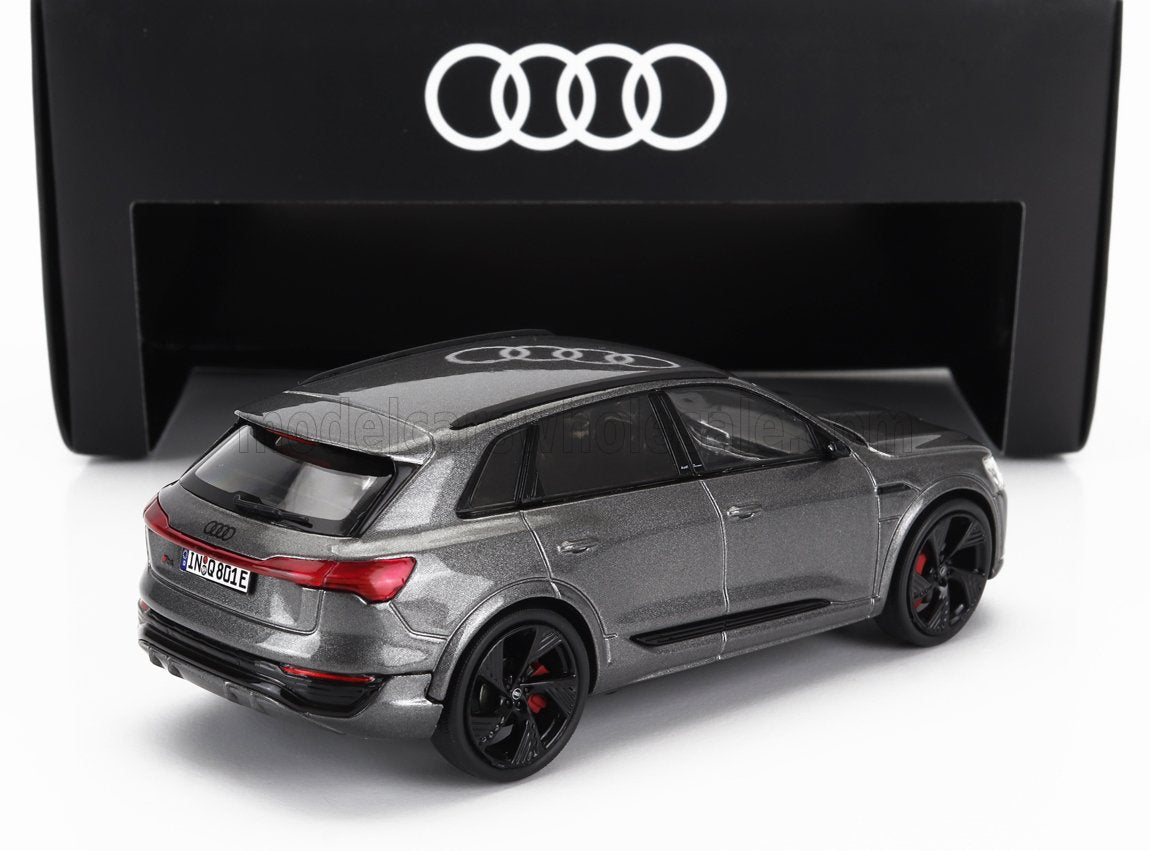 Modelo de coche Audi Q8 gris con ruedas negras expuesto con caja con el logotipo de Audi, disponible en Vroomi.