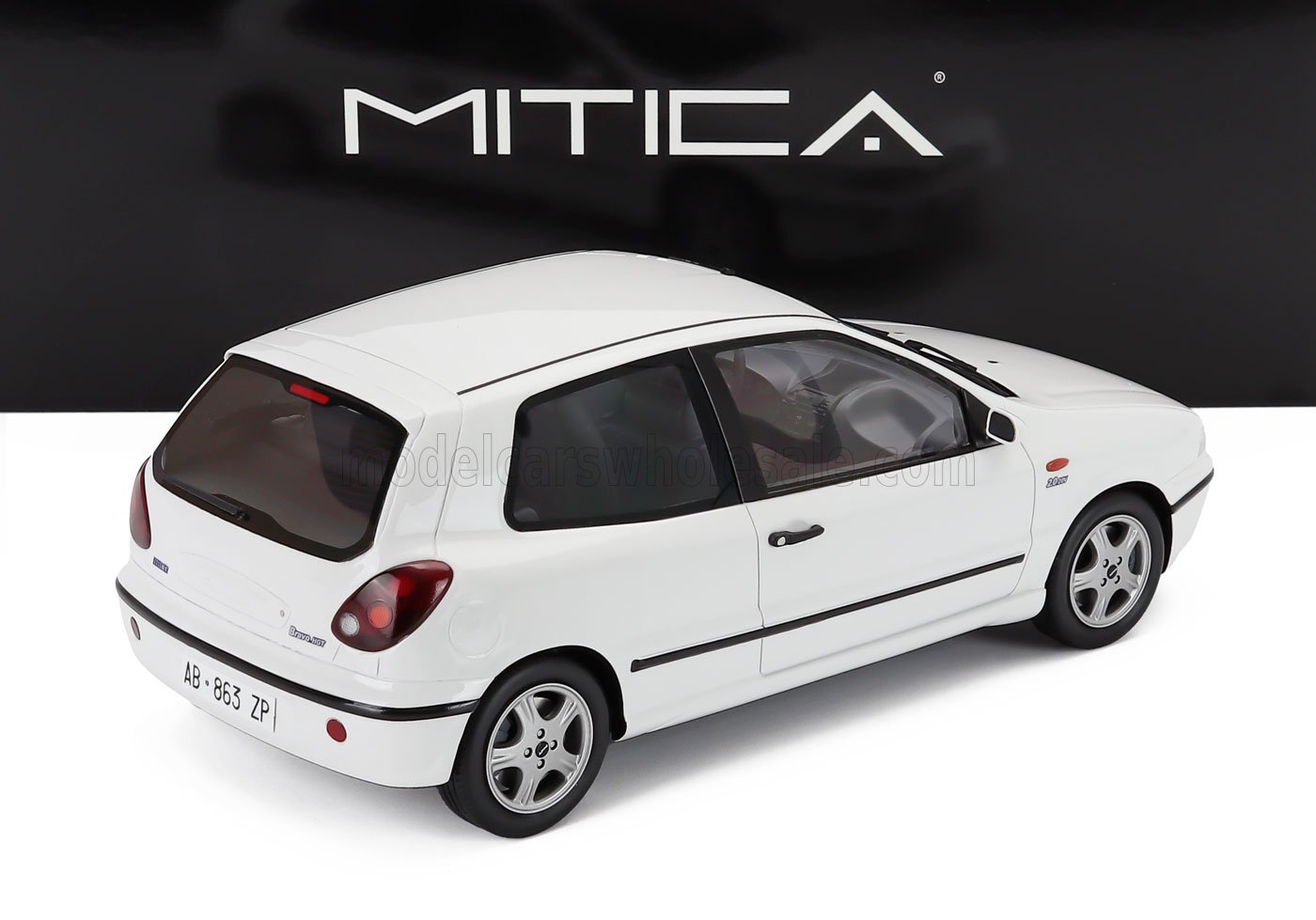 Modelo de coche blanco a escala 1/18 con llantas detalladas, disponible para coleccionistas en Vroomi.