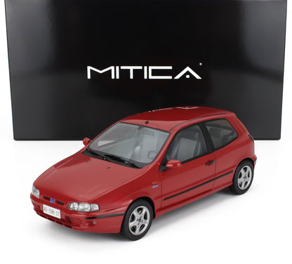 Coche modelo Fiat Bravo rojo a escala 1:18 delante de una caja Mitica negra, ahora disponible en Vroomi.