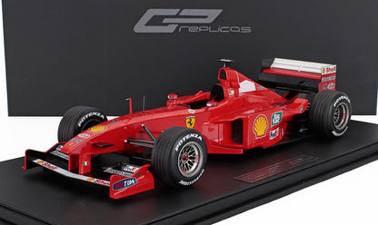 Coche de carreras Ferrari rojo de Fórmula 1 con logotipos de patrocinadores expuesto sobre una base negra, disponible a través de Vroomi.