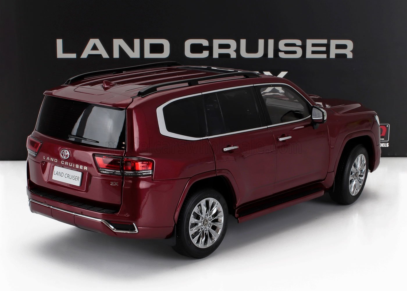 Maroon Toyota Land Cruiser ZX model SUV displayed with Land Cruiser sign, now offered on Vroomi