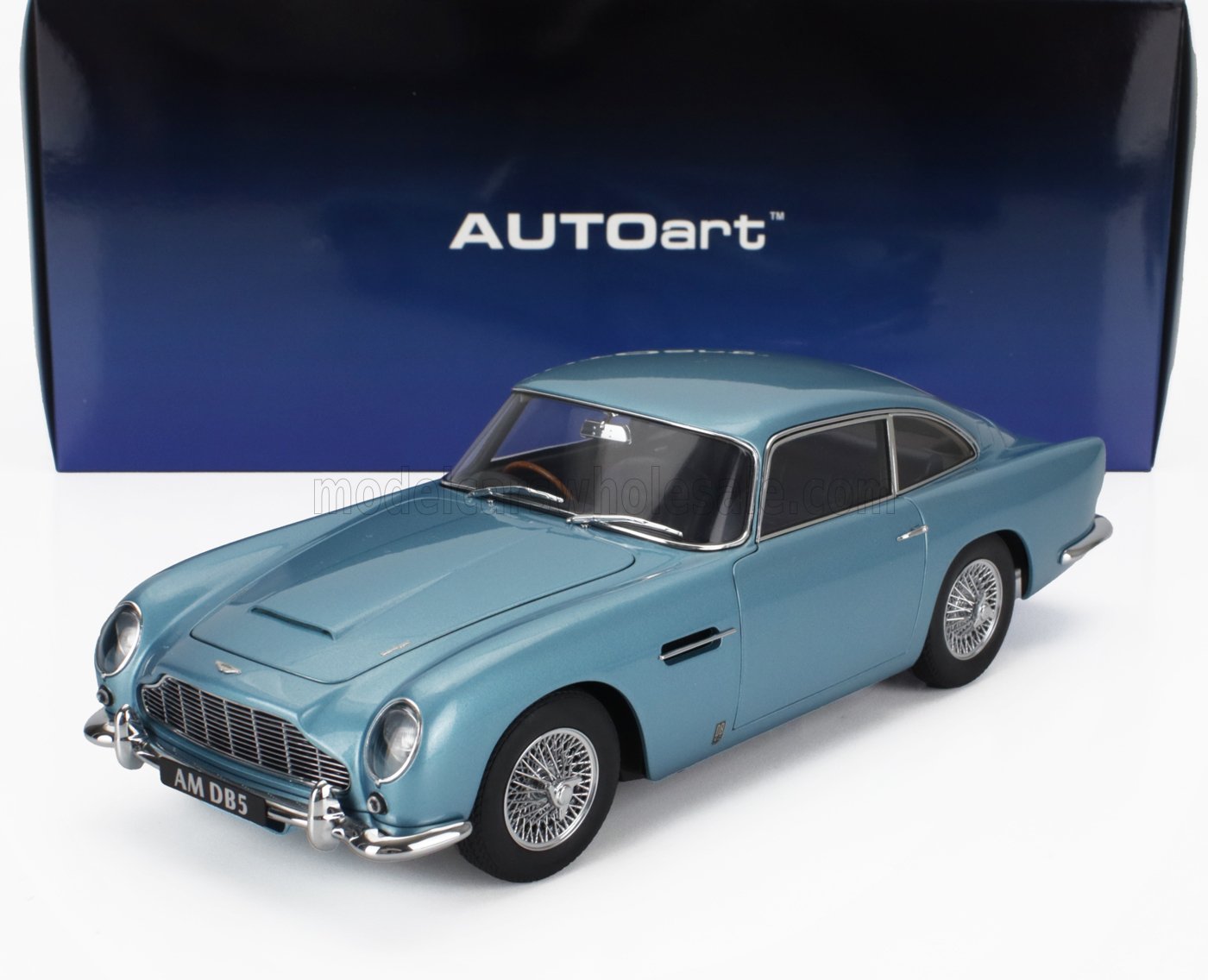 Modelo de coche Aston Martin DB5 azul claro con llantas de radios, expuesto con caja AUTOart, disponible en Vroomi.