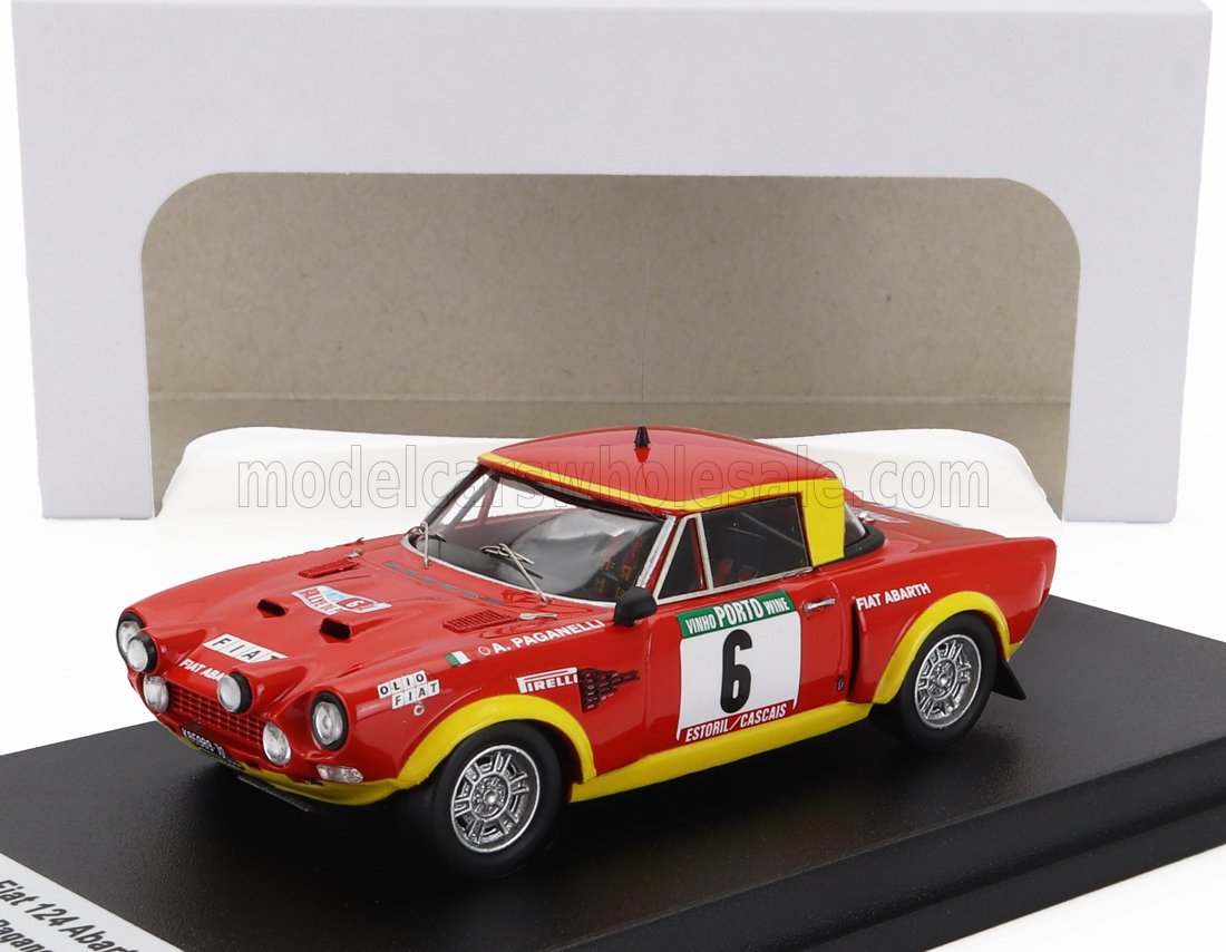 Modelo de coche de rally Fiat 124 Abarth rojo y amarillo con adhesivos de carreras en exposición, disponible en Vroomi.