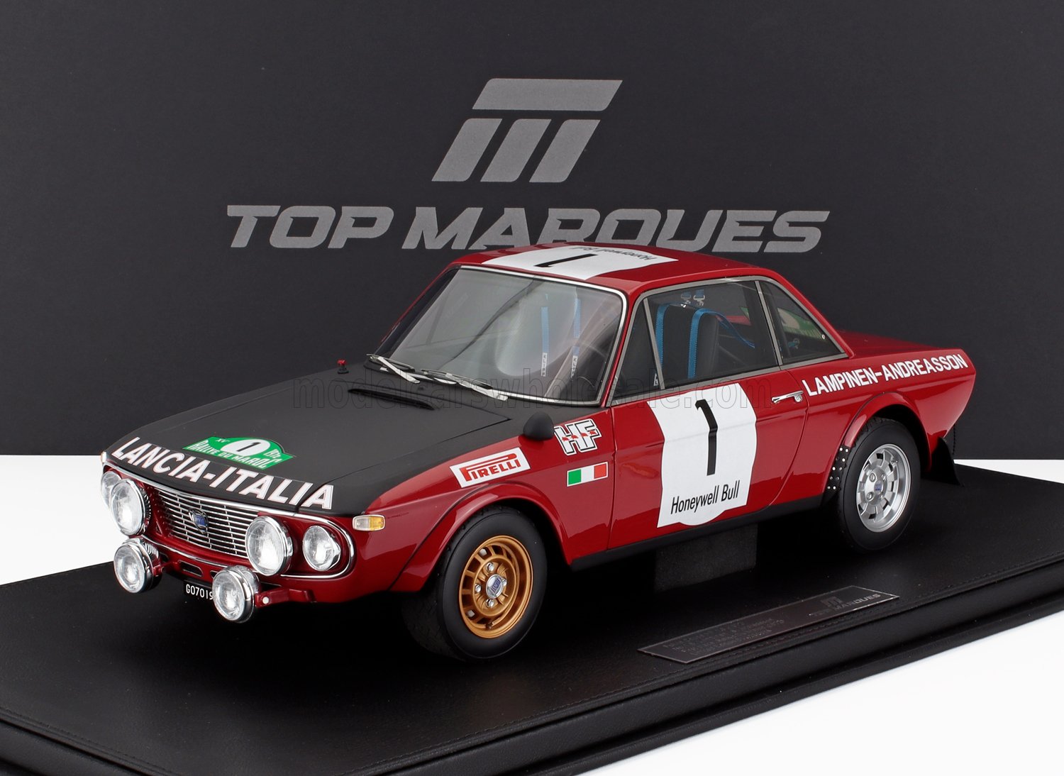 Modelo de coche de rally Lancia rojo y negro con adhesivos con el número 1, expuesto en el stand de Top Marques, también disponible a través de Vroomi.