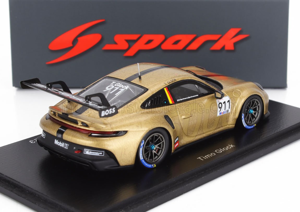 Gold Porsche 911 race car model by Timo Glock with sponsor decals on display, now offered on Vroomi