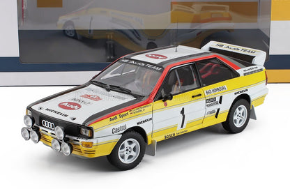Modelo de coche de rally Audi Quattro a escala 1:18 con decoración de competición, disponible en Vroomi para coleccionistas.