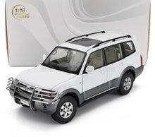 Maqueta a escala 1:18 del SUV Mitsubishi Pajero blanco con barra parachoques, disponible en Vroomi para coleccionistas.