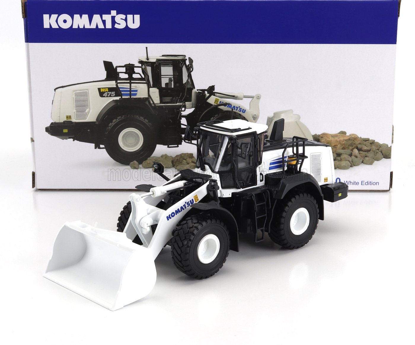 Cargadora Komatsu WA475 White Edition a escala con cabina y cuchara detalladas, presentada en su caja con la marca y rocas, disponible en Vroomi.
