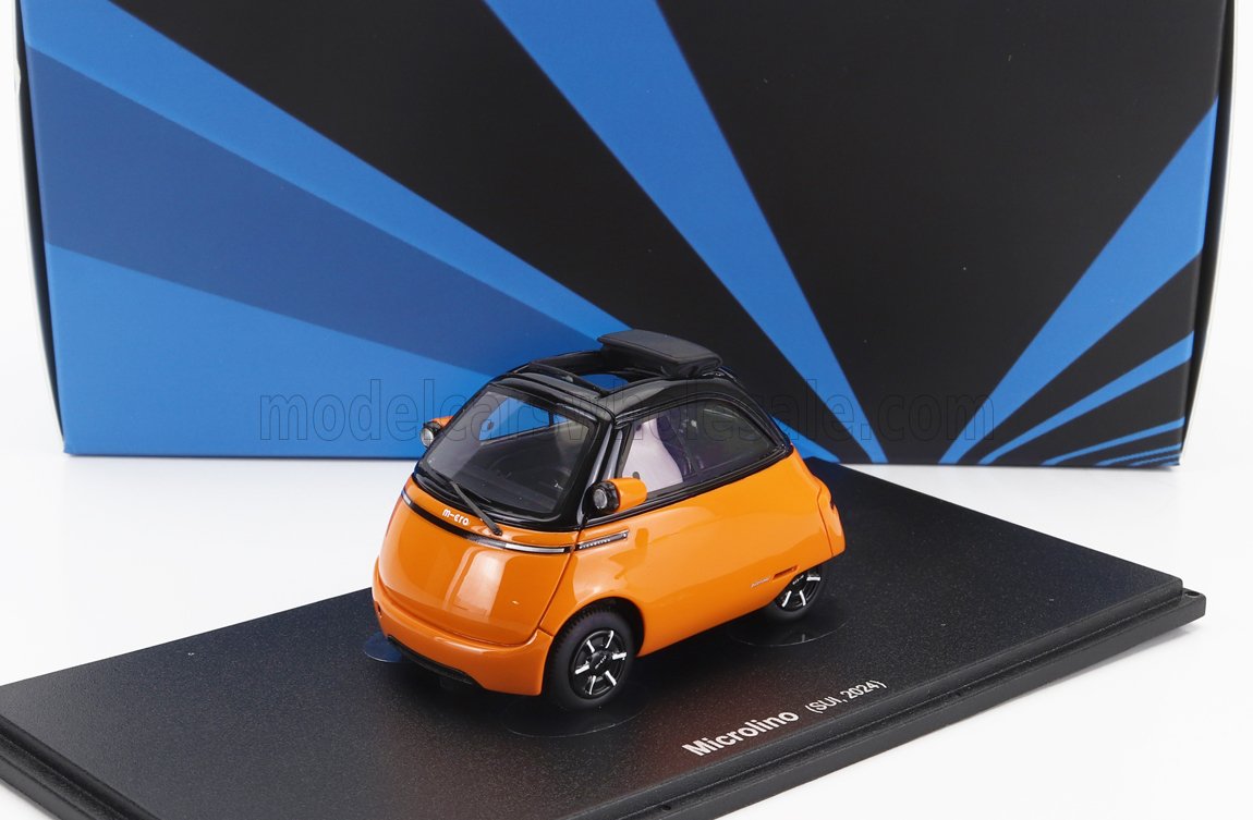 Coche modelo Microlino 2024 naranja y negro en expositor con fondo azul estampado, disponible en Vroomi.