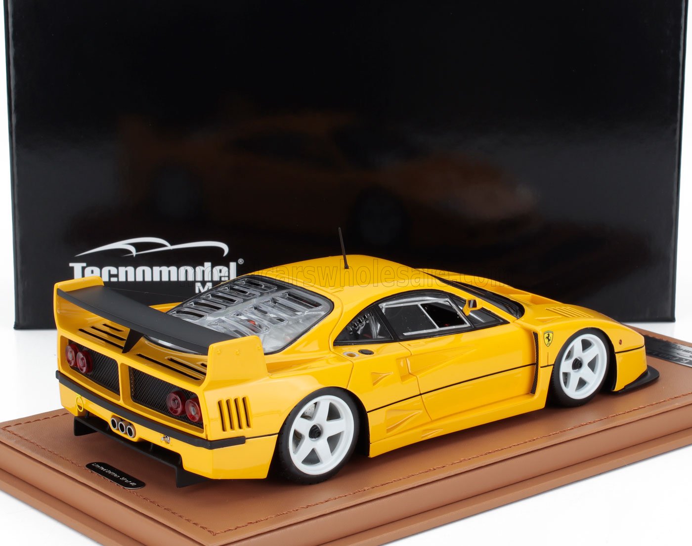 Maqueta a escala de un Ferrari F40 amarillo con ruedas blancas sobre una base marrón, presentada en la plataforma Vroomi.