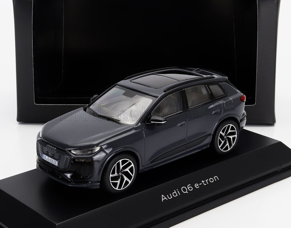 Maqueta en miniatura del Audi Q6 e-tron en color negro sobre un soporte de exposición, disponible en la plataforma Vroomi.