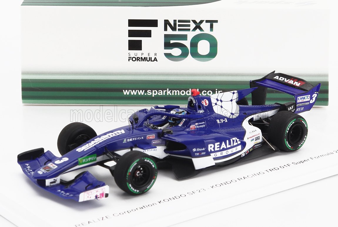 Coche modelo Blue KONDO SF23 Super Formula con patrocinadores, detallado delante de la caja Next 50, presentado en Vroomi.