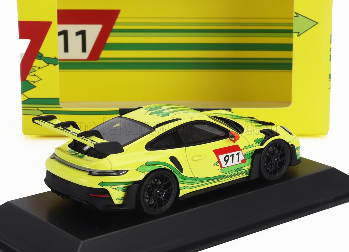 Yellow Porsche 911 GT3 model car with green arrow graphics on black stand, featured on Vroomi