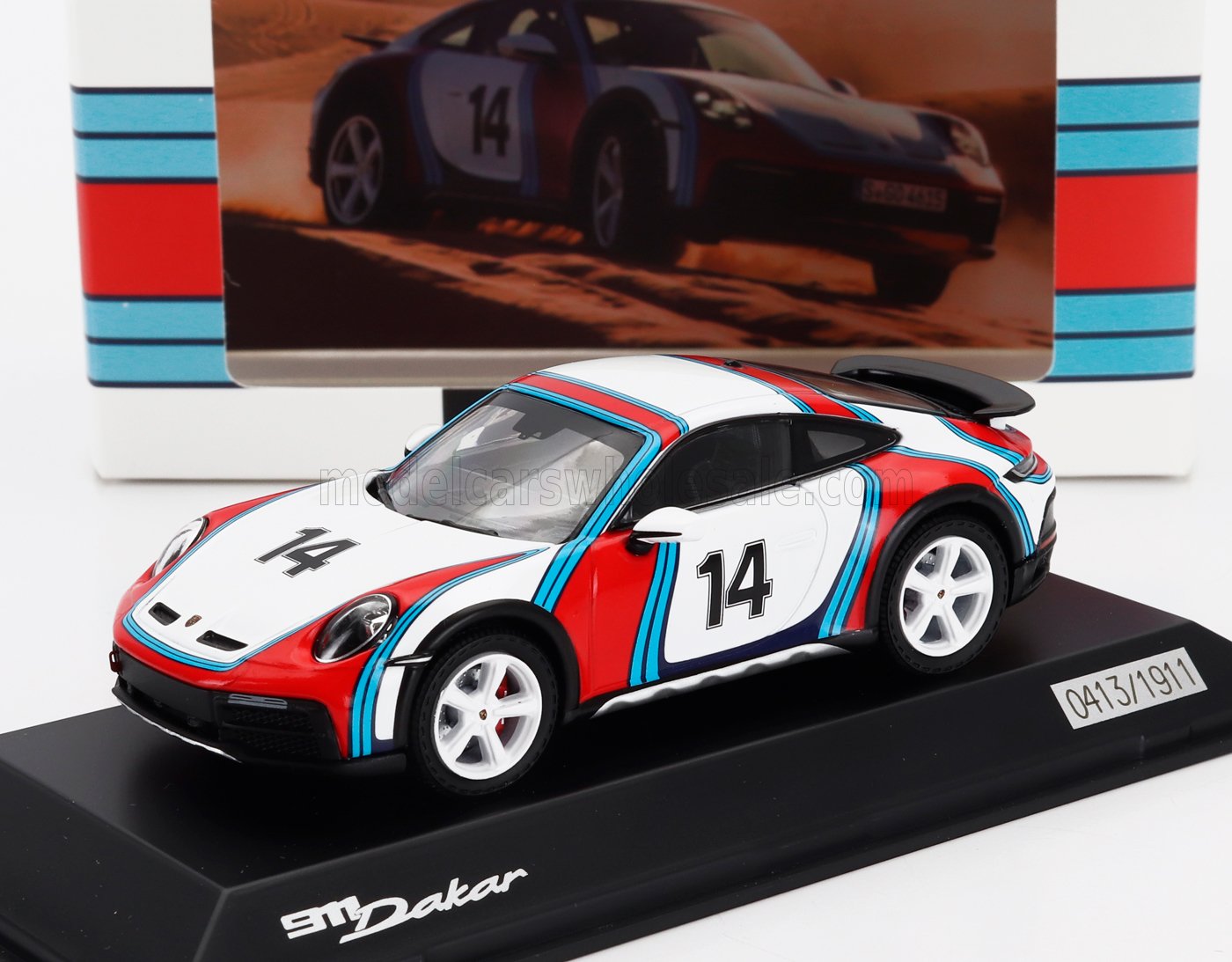 Coche modelo 911 Dakar con el número 14, diseño en blanco, rojo y azul sobre un expositor, disponible en Vroomi.