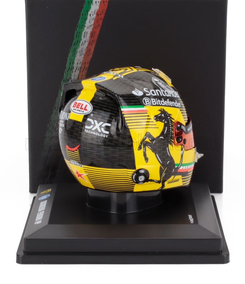 Casco de carreras Ferrari negro y amarillo con logotipos de patrocinadores en un expositor, disponible a través de Vroomi.