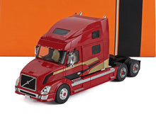 Modelo de camión Volvo rojo con rayas doradas y negras, coche coleccionable de metal disponible en Vroomi.