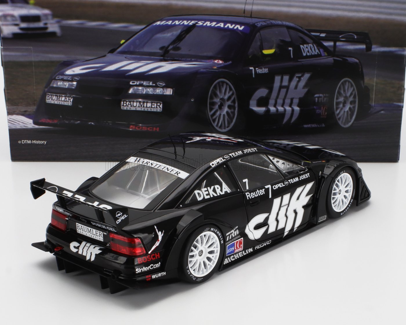 Black Opel Team Joest DTM model car with Clif branding, detailed decals, and white rims, shown with racing poster, available on Vroomi