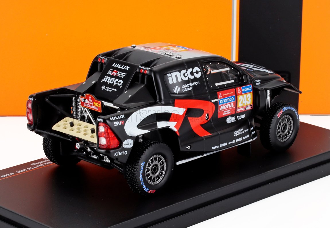 Maqueta a escala del camión de rally Toyota Hilux GR negro con adhesivos de carreras, expuesta con disponibilidad en Vroomi.