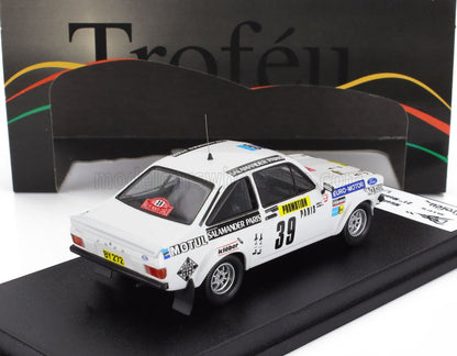 Modelo de coche de rally Ford Escort Mk2 blanco con adhesivos de carreras en exposición, ofrecido en Vroomi.