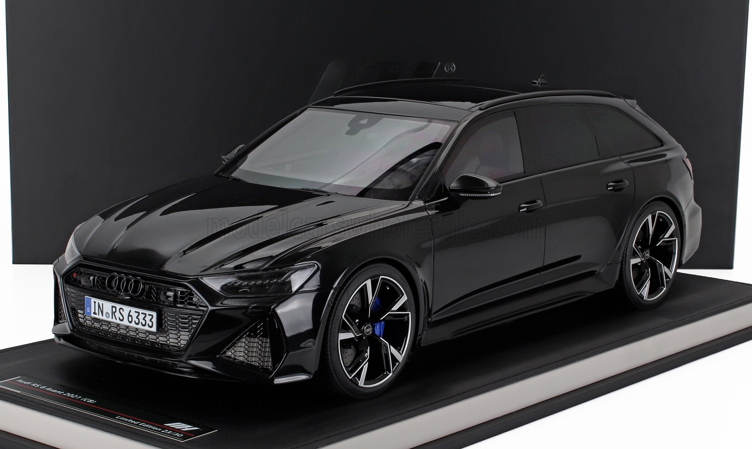 Coche modelo Audi RS6 Avant 2021 negro con acabado brillante expuesto en una plataforma, disponible a través de Vroomi.