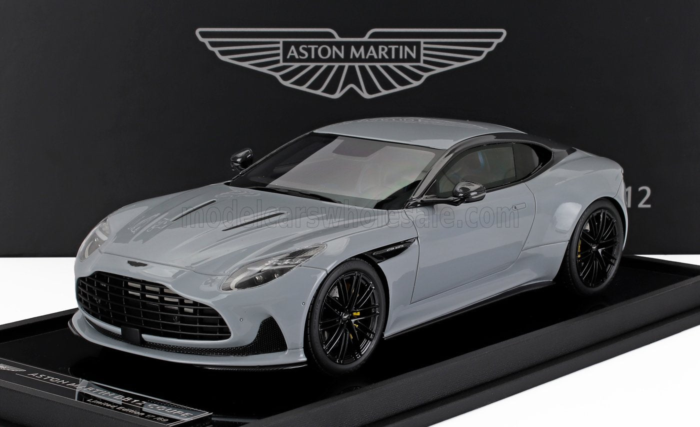 Modelo Aston Martin DB11 Coupé gris expuesto sobre una base negra con el logotipo de Aston Martin, disponible en Vroomi.