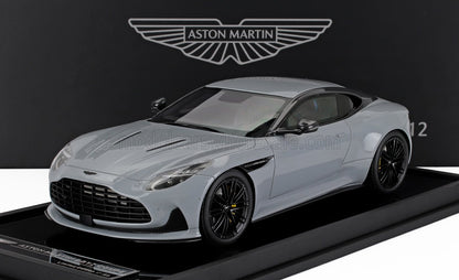 Modelo Aston Martin DB11 Coupé gris expuesto sobre una base negra con el logotipo de Aston Martin, disponible en Vroomi.