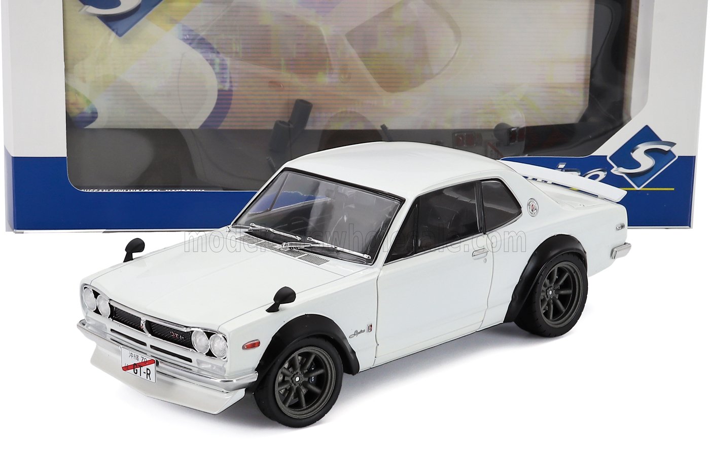 Modelo clásico de coche a escala 1/18 en color blanco con ruedas negras, disponible ahora online para coleccionistas.