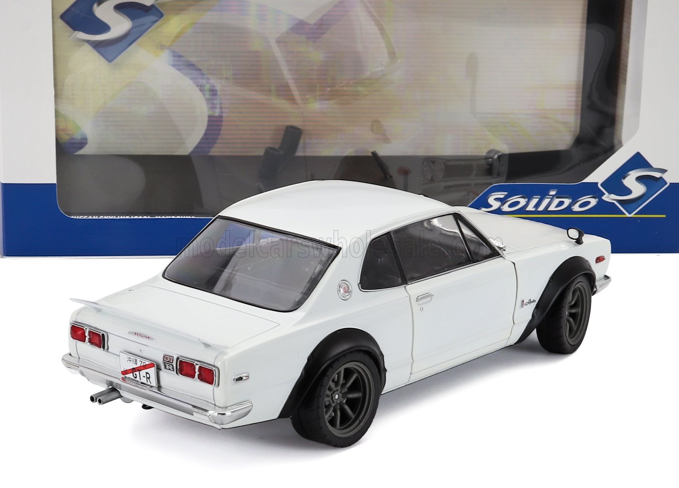 Modelo clásico de coche a escala 1:18 en color blanco, fabricado en metal fundido, ya disponible para coleccionistas en Vroomi.