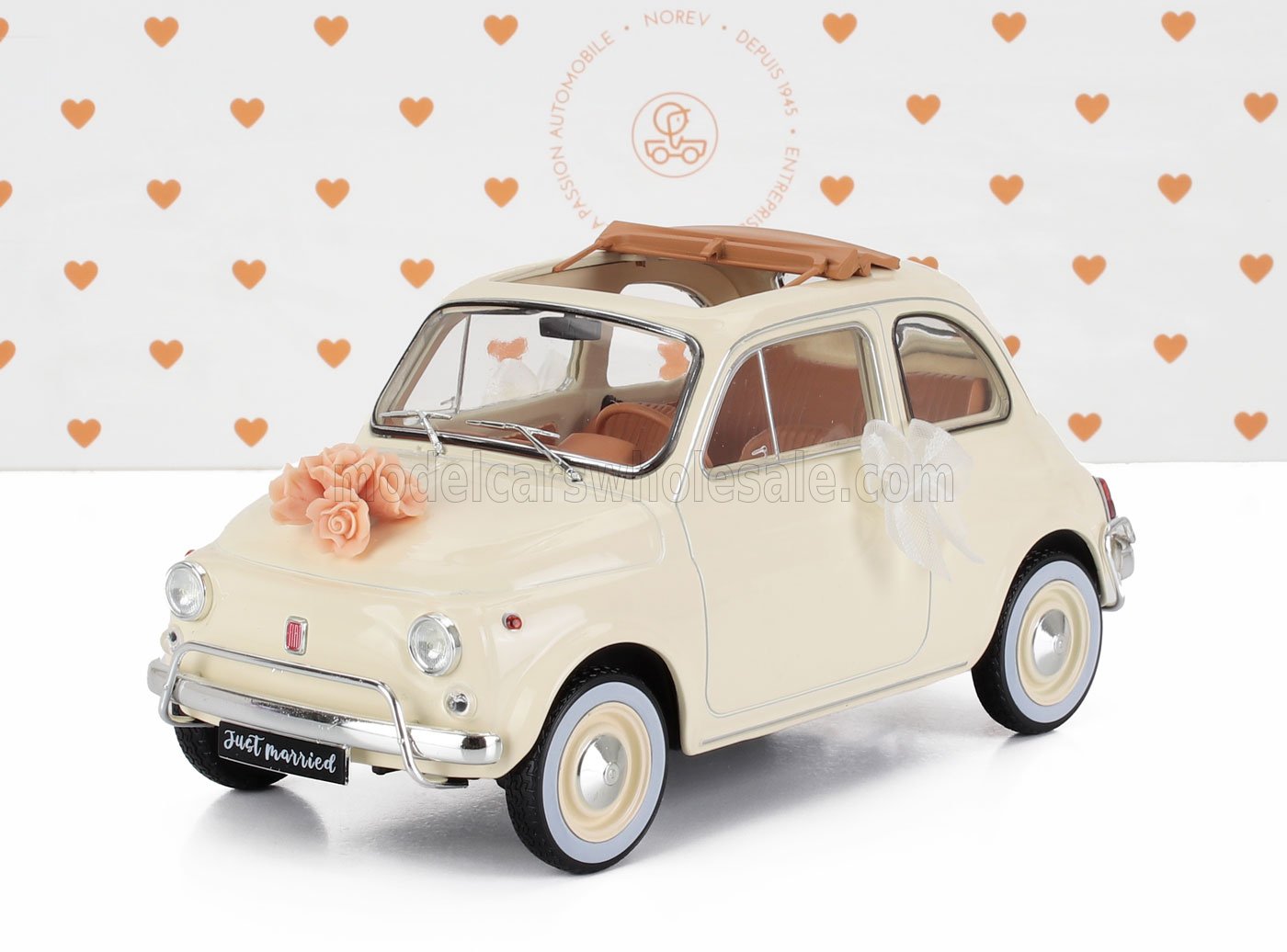 Modelo Fiat 500 vintage color crema con decoraciones nupciales y placa «Just married» disponible en Vroomi.