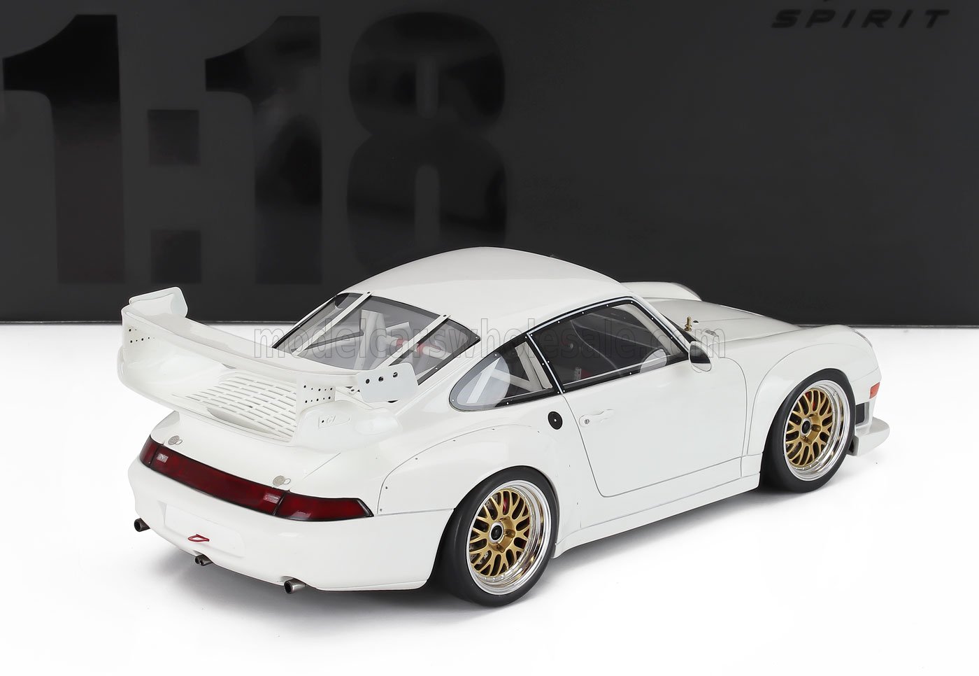 White 1:18 scale Porsche 911 model car with gold rims and large rear spoiler available at Vroomi