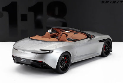 Maqueta a escala del Aston Martin DB12 descapotable plateado con interior marrón y llantas negras, disponible en Vroomi.