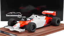 Modelo a escala 1:18 blanco y rojo de un coche de carreras de Fórmula 1 vintage con el número 7, presentado sobre una base marrón, disponible en Vroomi.