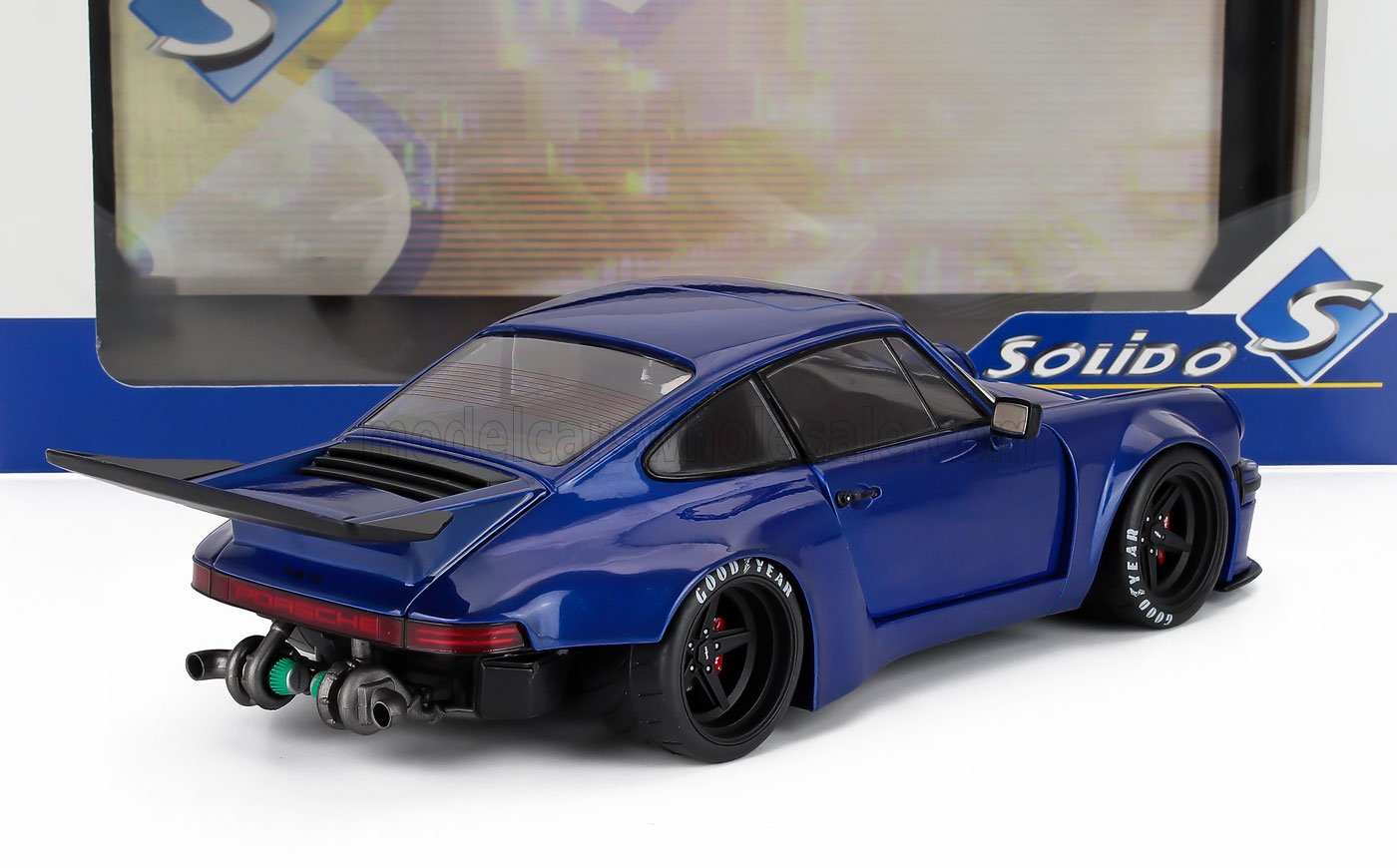 Modelo de coche Porsche 911 azul con kit de carrocería ancha negro y alerón trasero, expuesto con embalaje Solido, disponible en Vroomi.