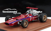 Modelo vintage rojo de coche de carreras Ferrari con el número 7, motor detallado y figura del piloto, disponible a través de Vroomi.