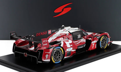 Modelo de coche de carreras híbrido Toyota rojo y blanco con logotipos detallados de los patrocinadores, presentado con disponibilidad en Vroomi.