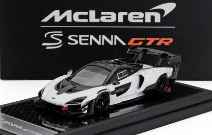 Maqueta de coche McLaren Senna GTR en blanco y negro expuesta con un fondo con la marca, disponible en Vroomi.