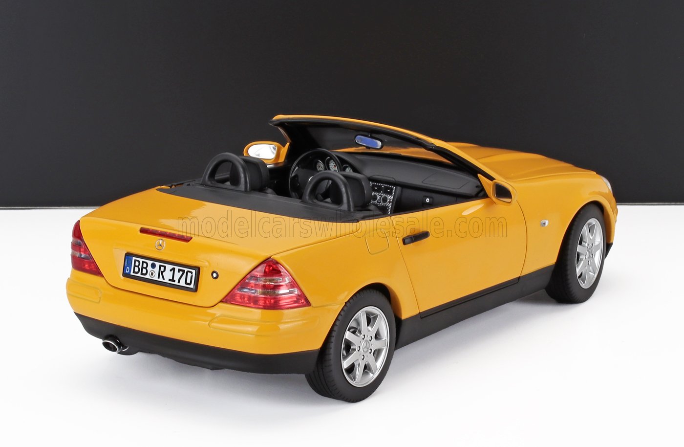 Modelo de coche descapotable Mercedes-Benz amarillo visto desde atrás, con interior detallado, disponible en Vroomi.