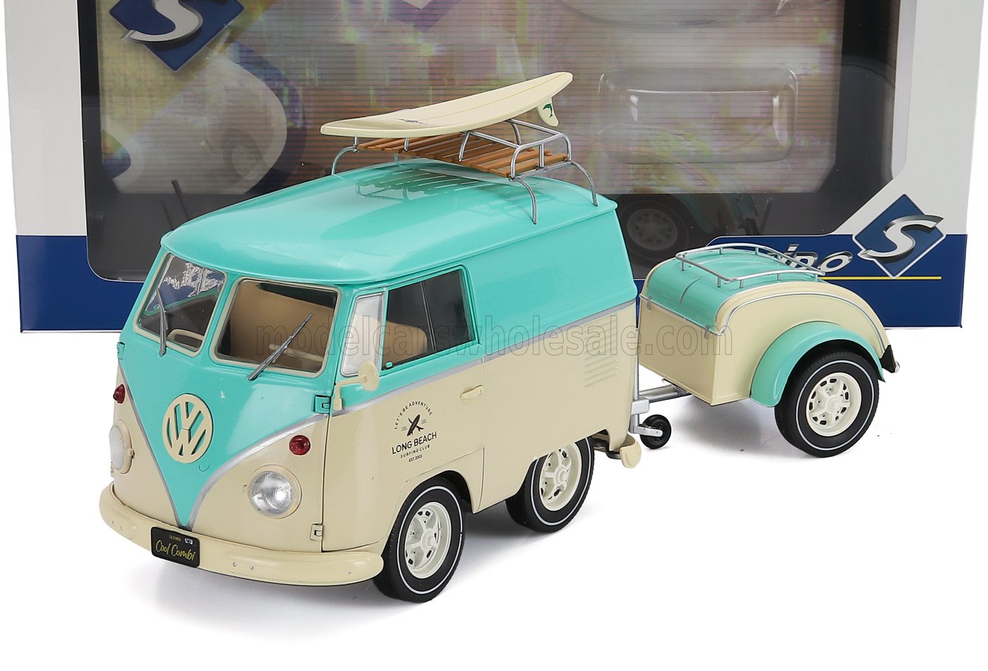 Modelo a escala 1/18 de una furgoneta Volkswagen vintage con tabla de surf y remolque, coche de colección disponible online.