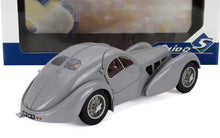 Coche de juguete vintage gris con curvas elegantes y ruedas de radios metálicos, disponible en la plataforma Vroomi.