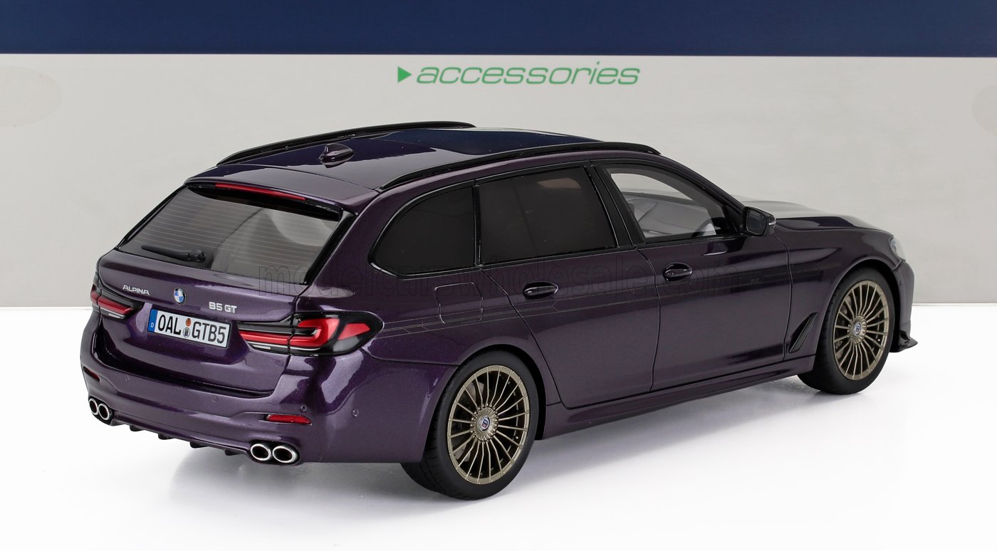 Alpina B5 GT, una lujosa camioneta familiar de color morado con distintivas llantas doradas, presentada con accesorios, disponible en Vroomi.