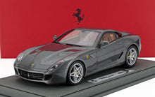 Maqueta a escala 1:18 del Ferrari 599 GTB Fiorano en gris metalizado, expuesta sobre una base, disponible bajo pedido.